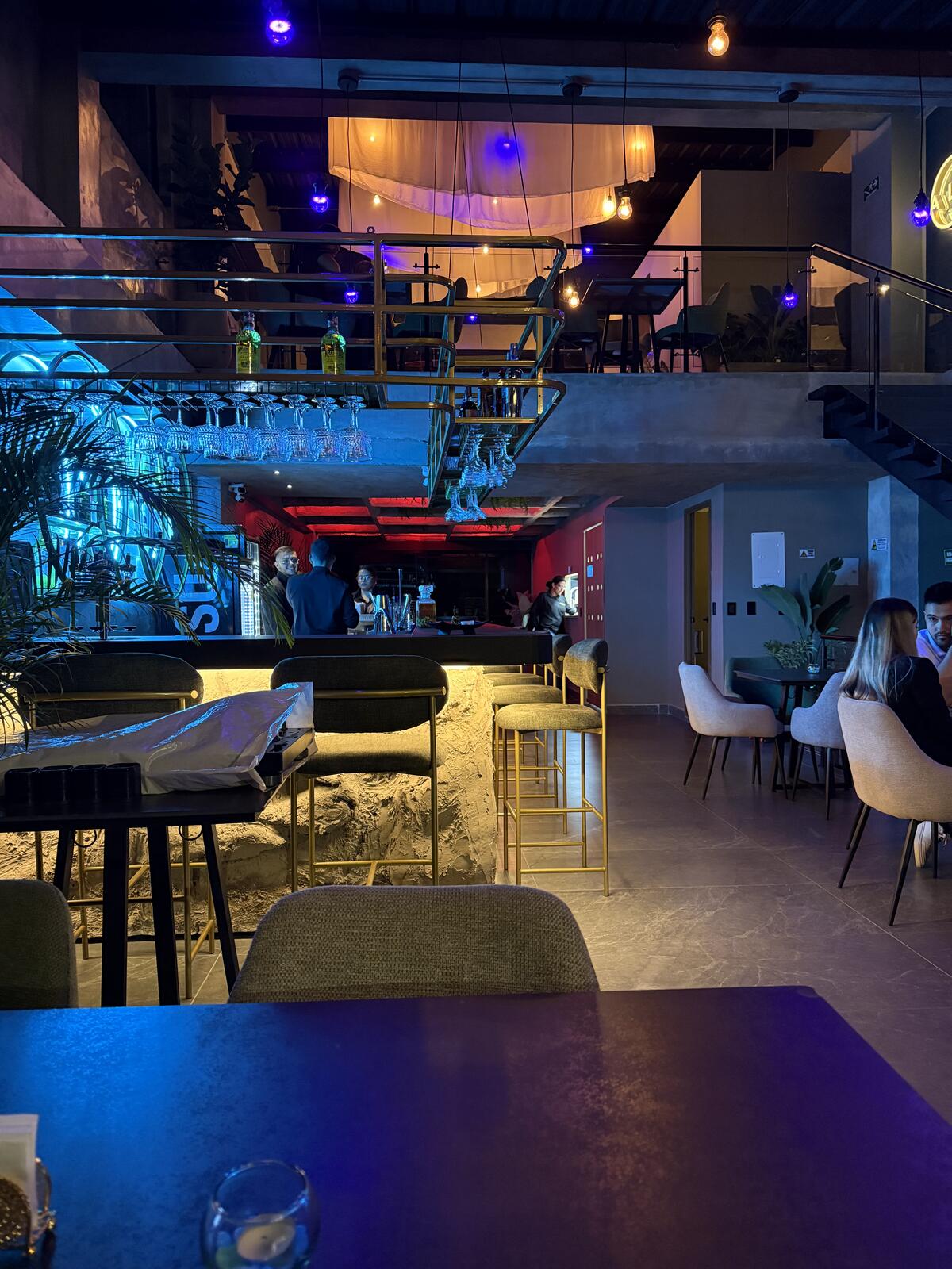 Los dos niveles vistos desde el salón: la barra abajo y el altillo con su escalera